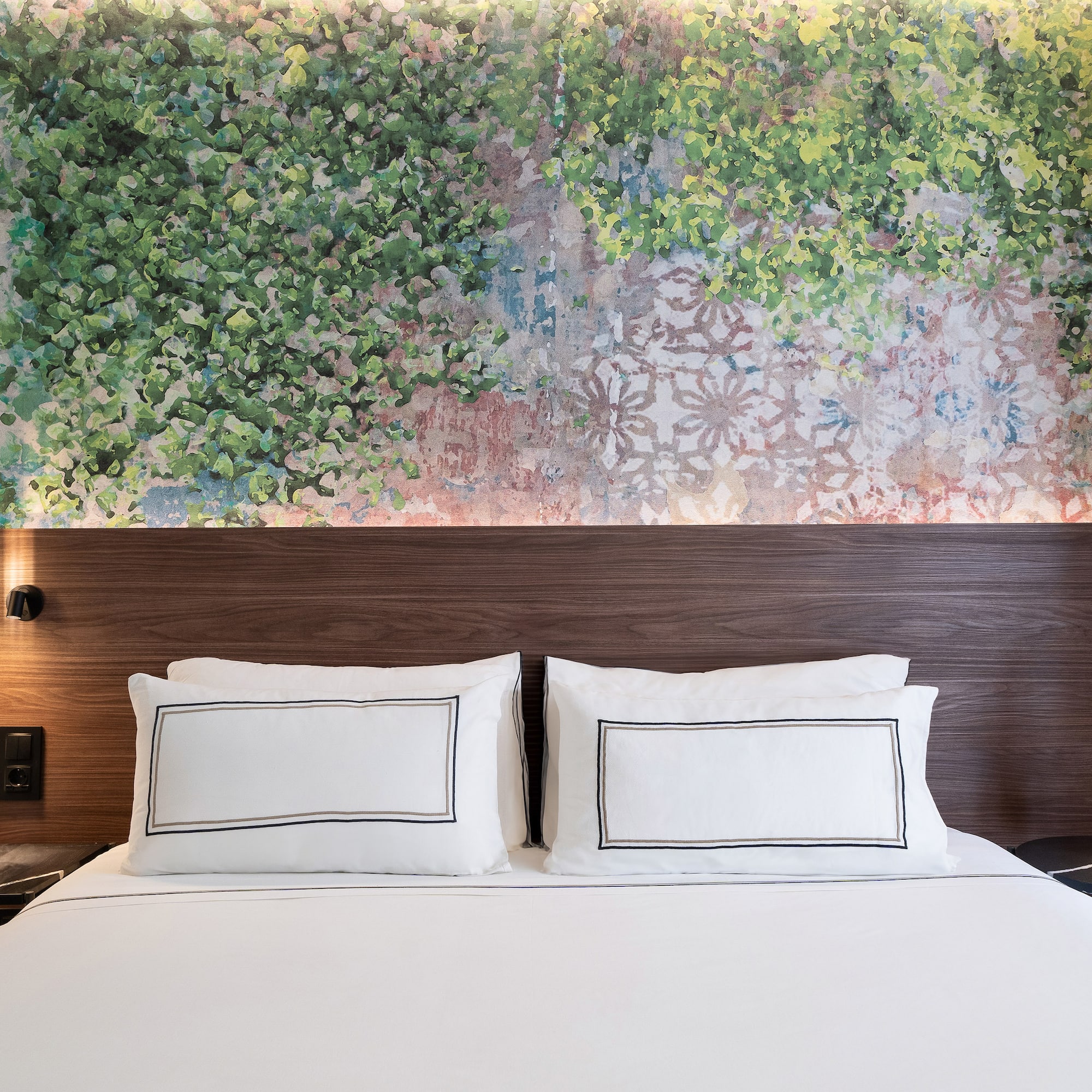 a bed with white sheets and a wood headboard