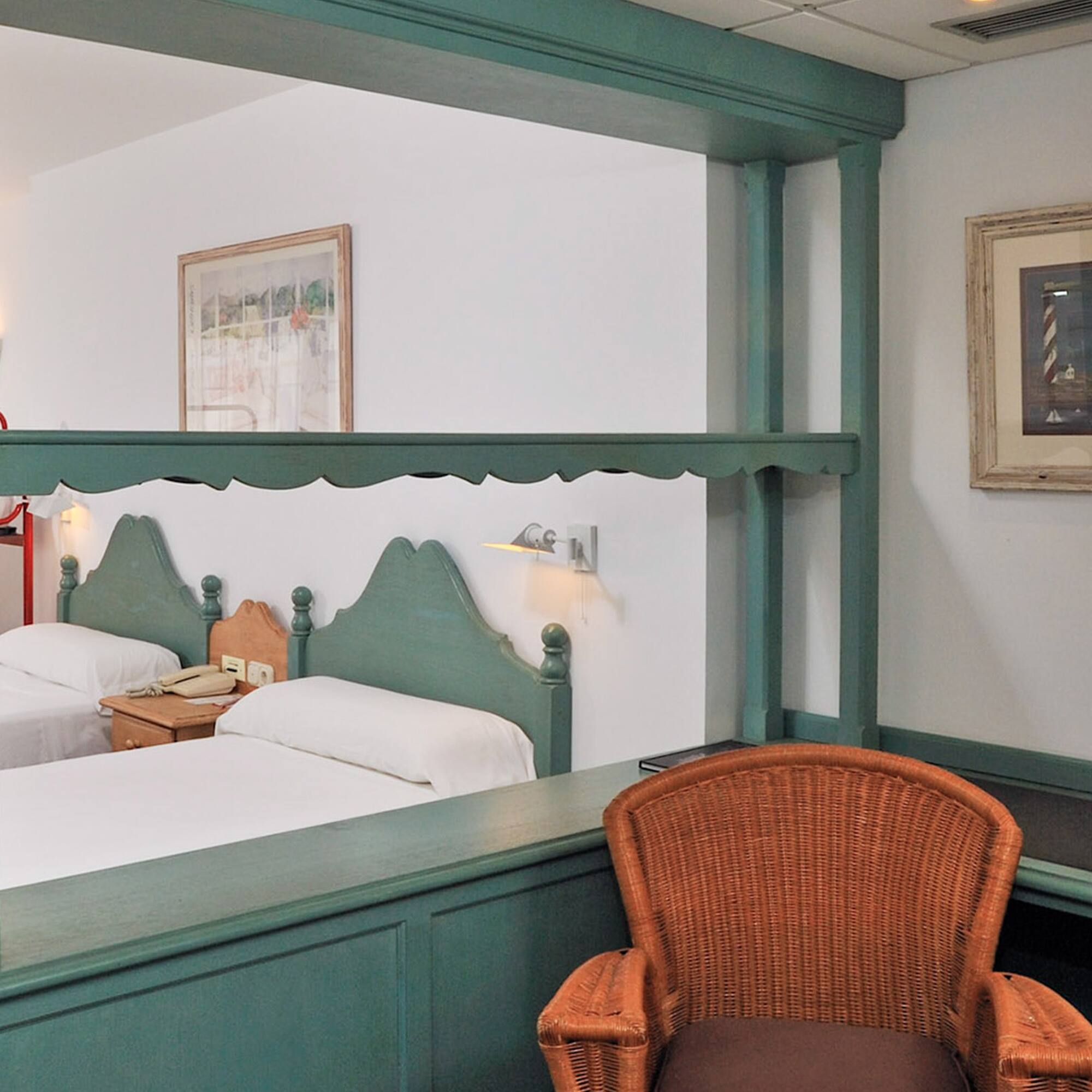 a room with two beds and a chair