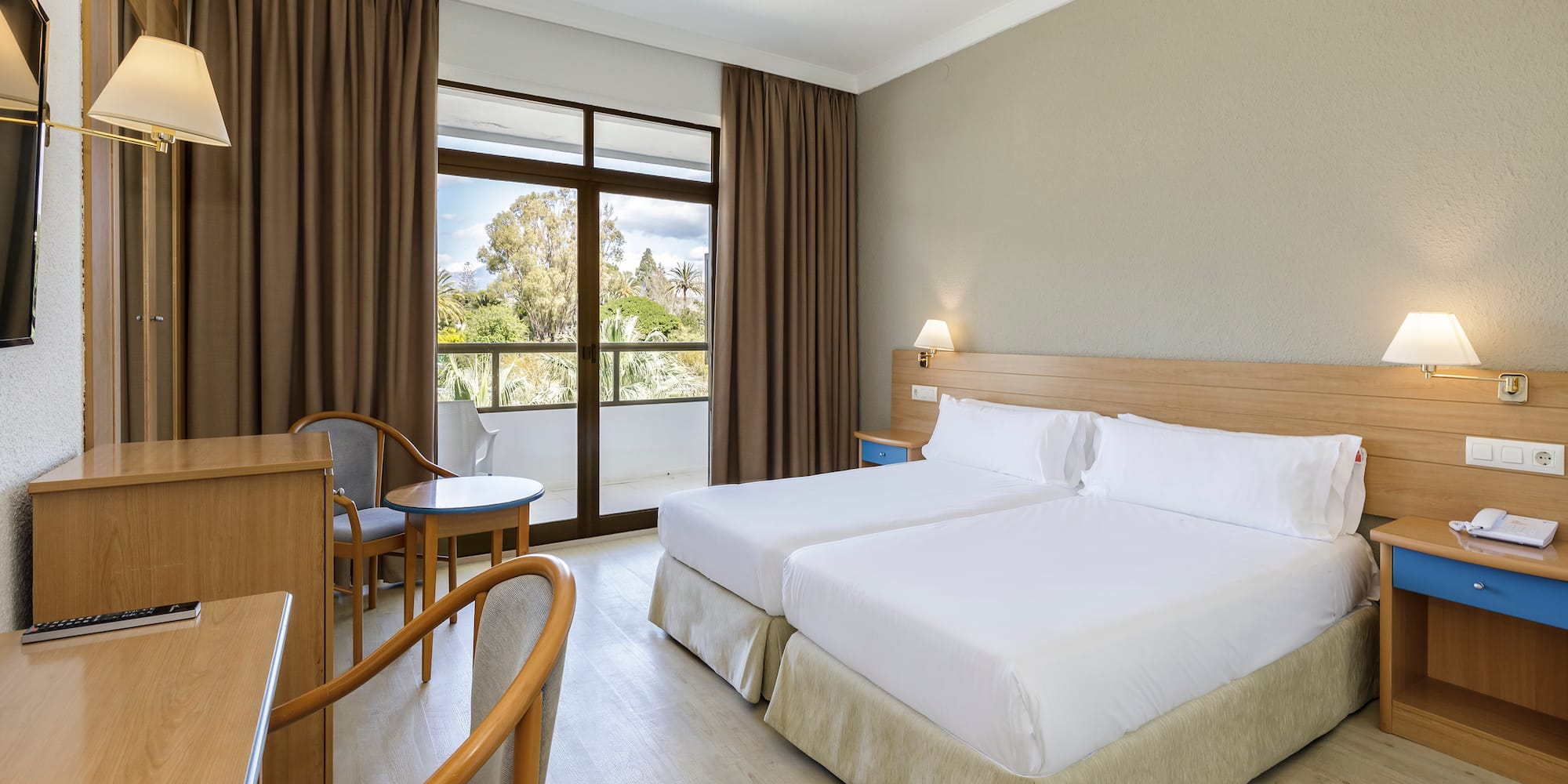 a room with two beds and a table and chairs