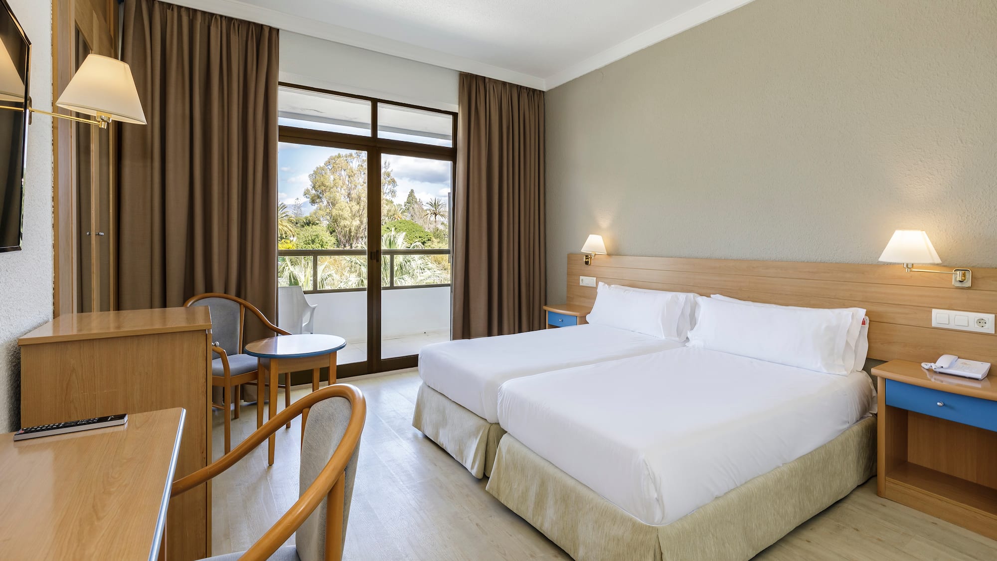 a room with two beds and a table and chairs