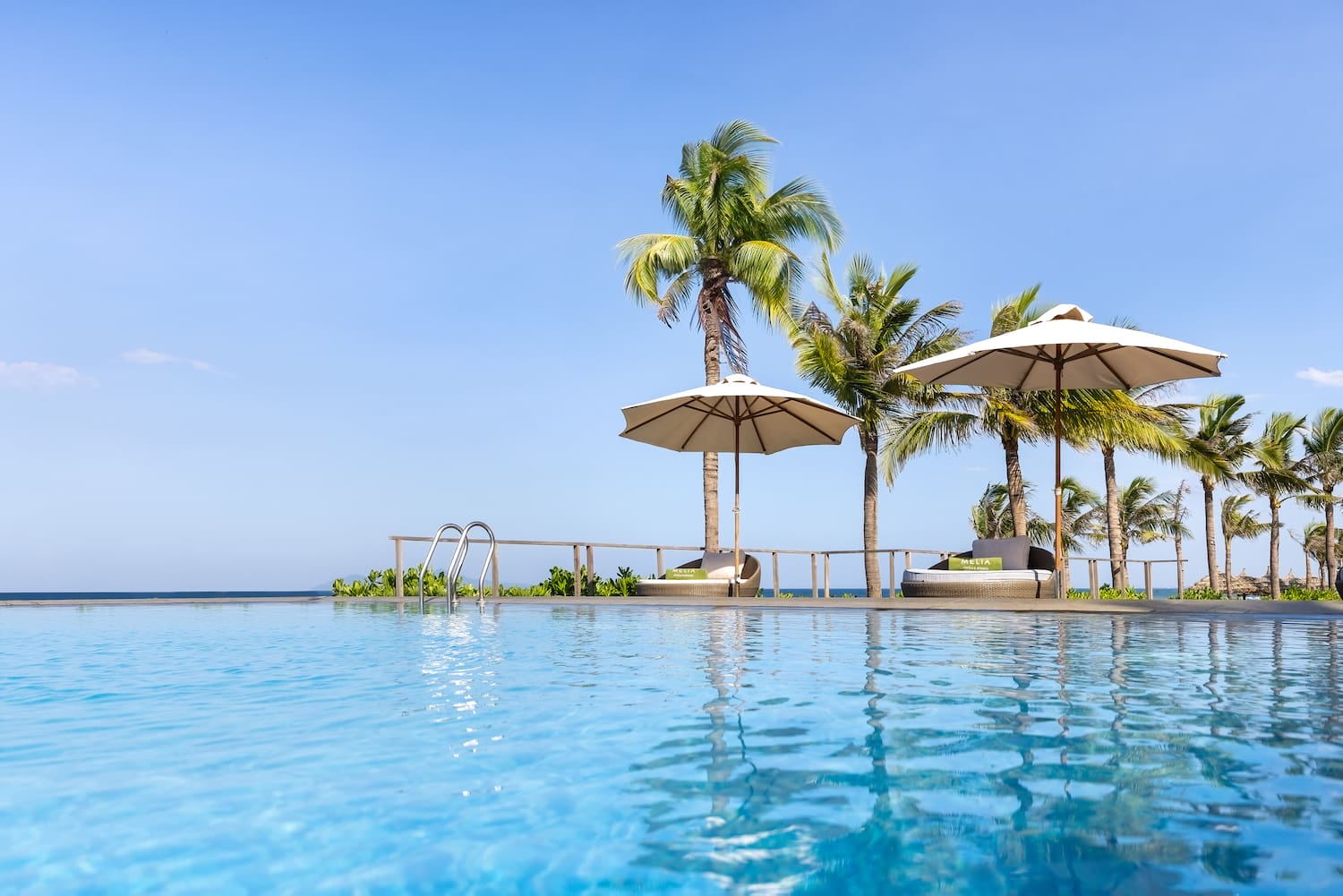 a pool with umbrellas and palm trees