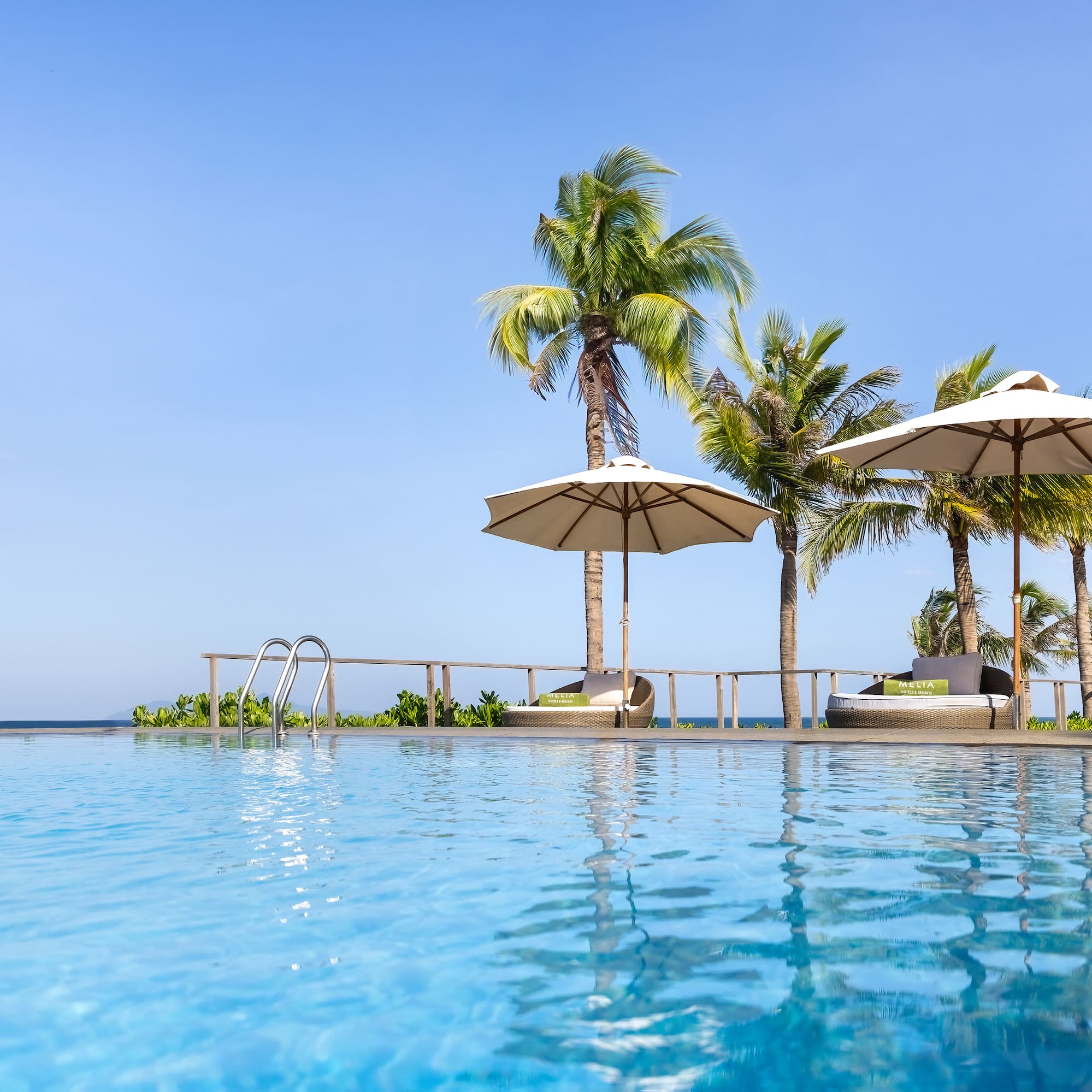 a pool with umbrellas and palm trees