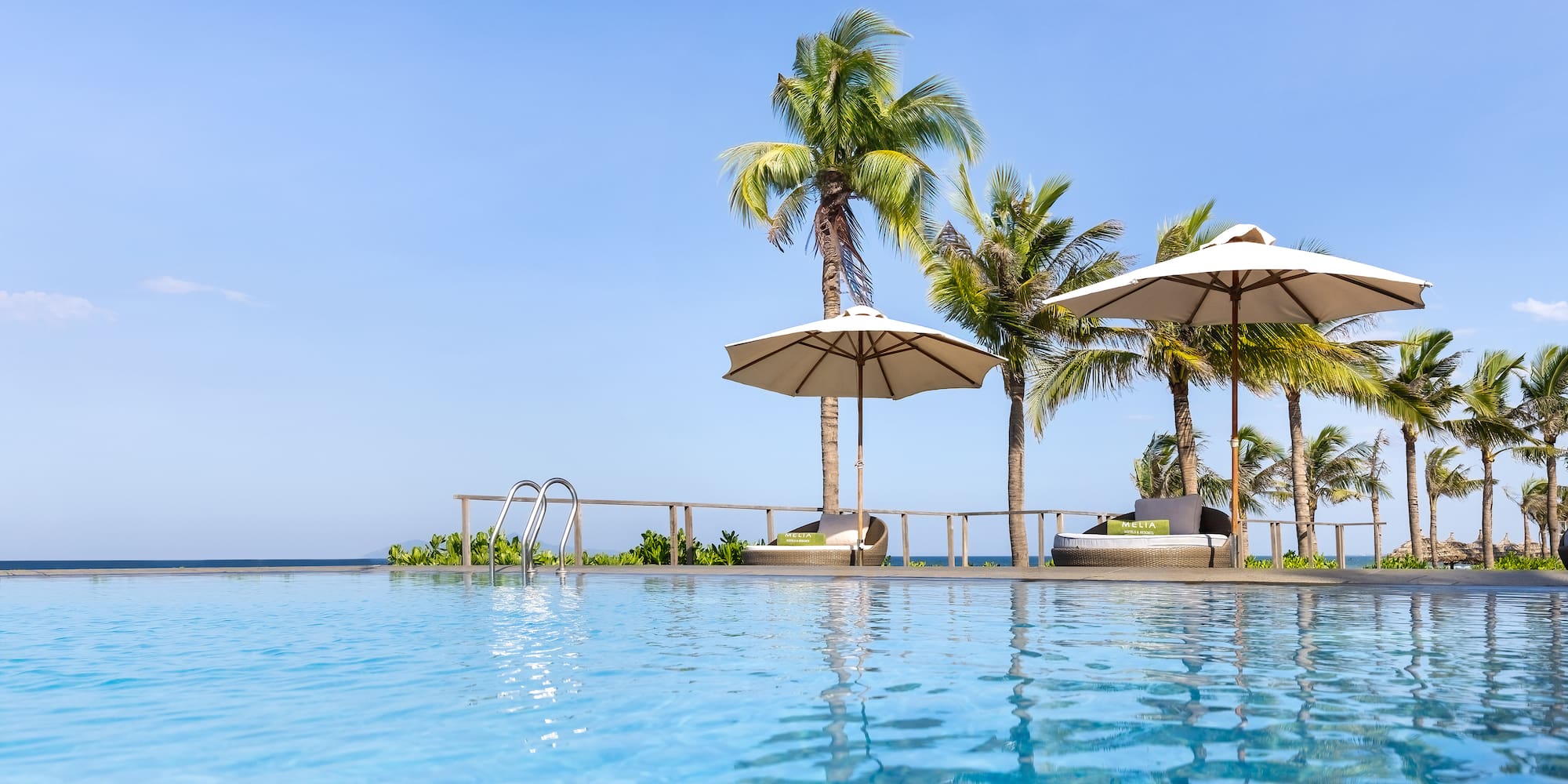 a pool with umbrellas and palm trees