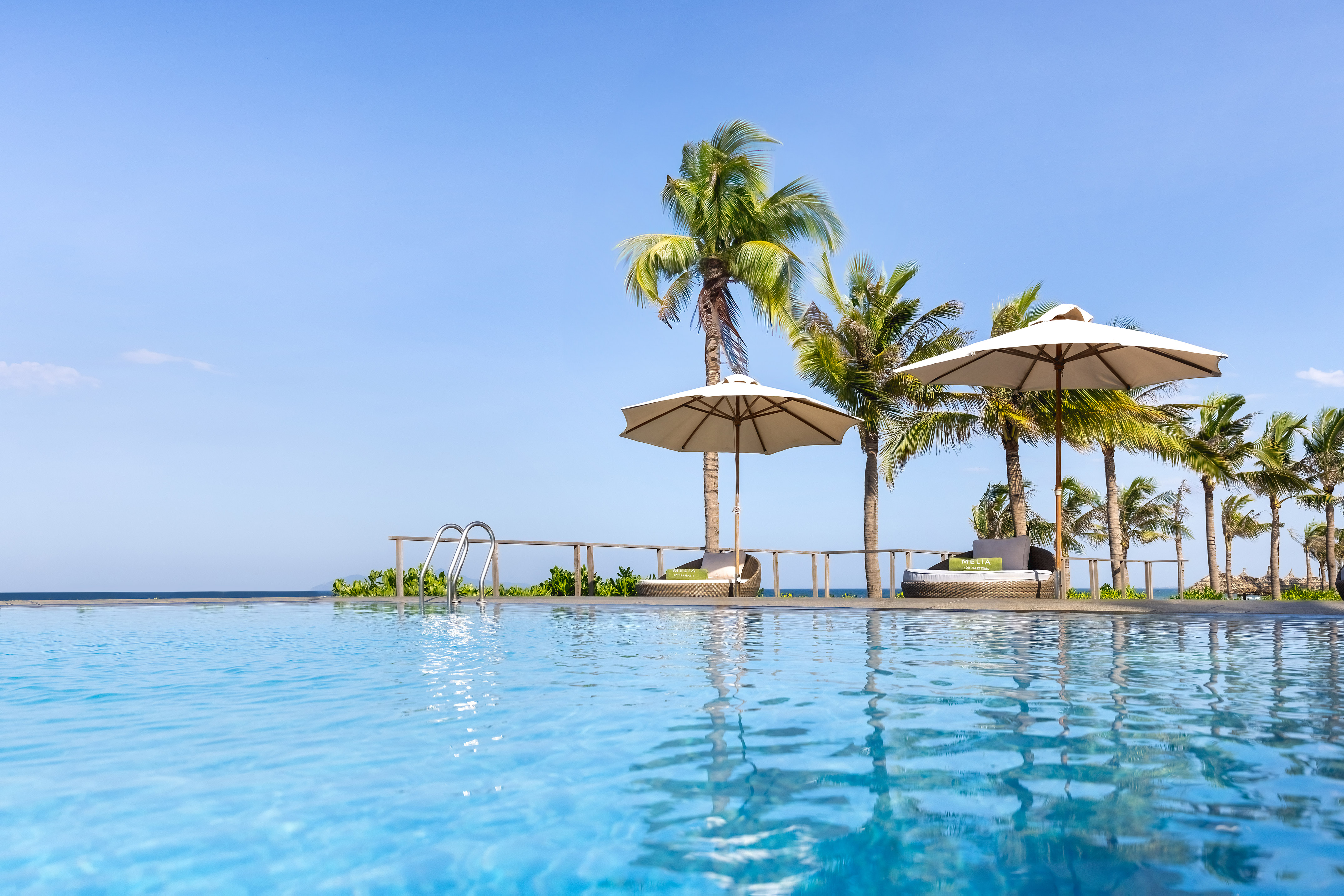 a pool with umbrellas and palm trees
