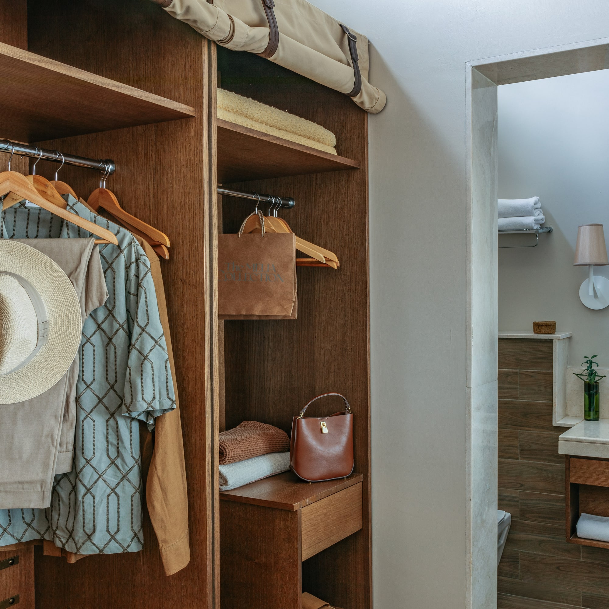 a closet with clothes on swingers and a towel