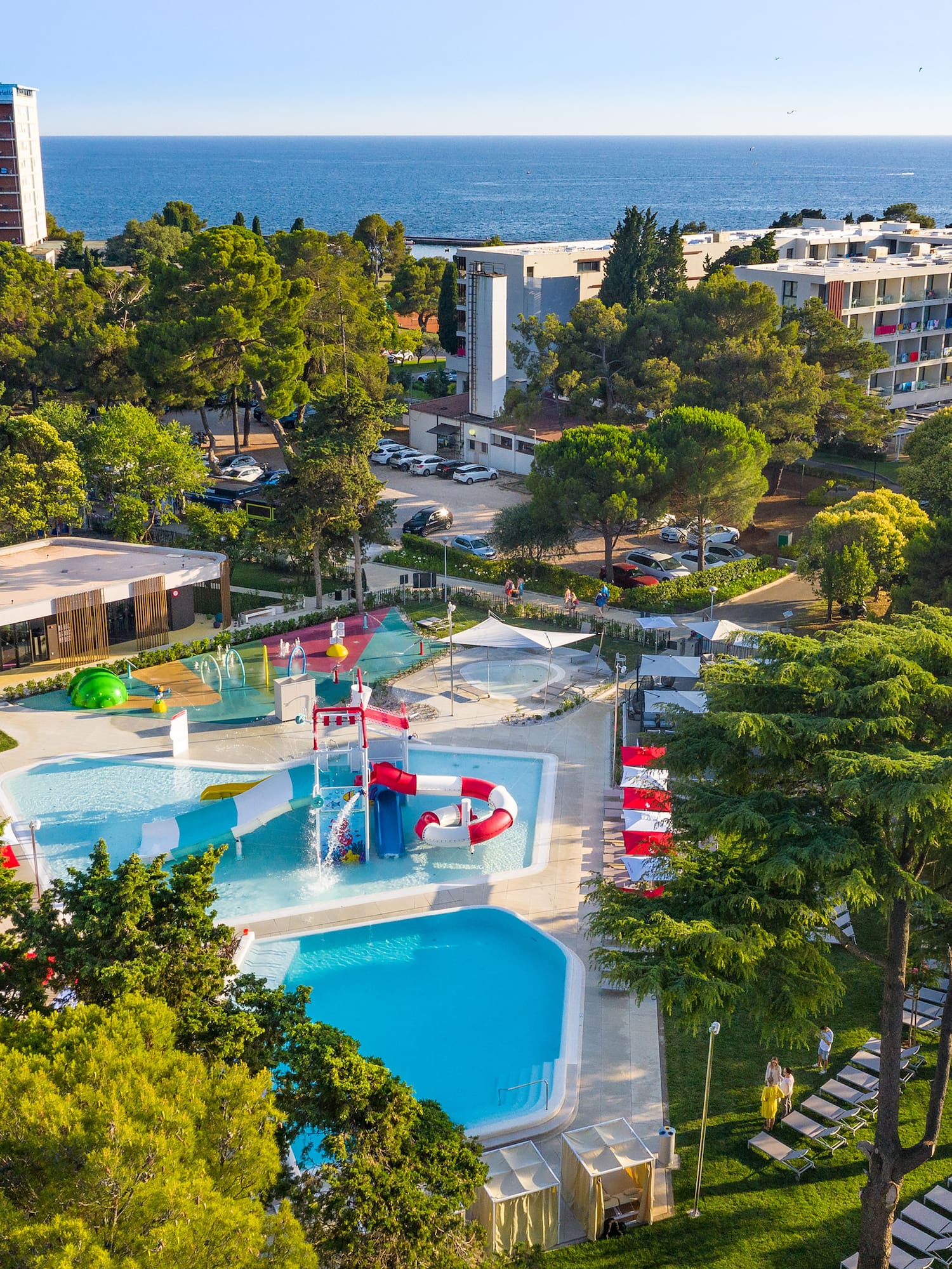 a swimming pool and trees by a building