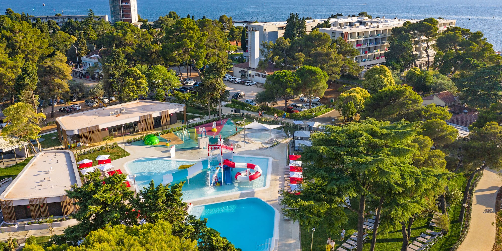 a swimming pool and trees by a building