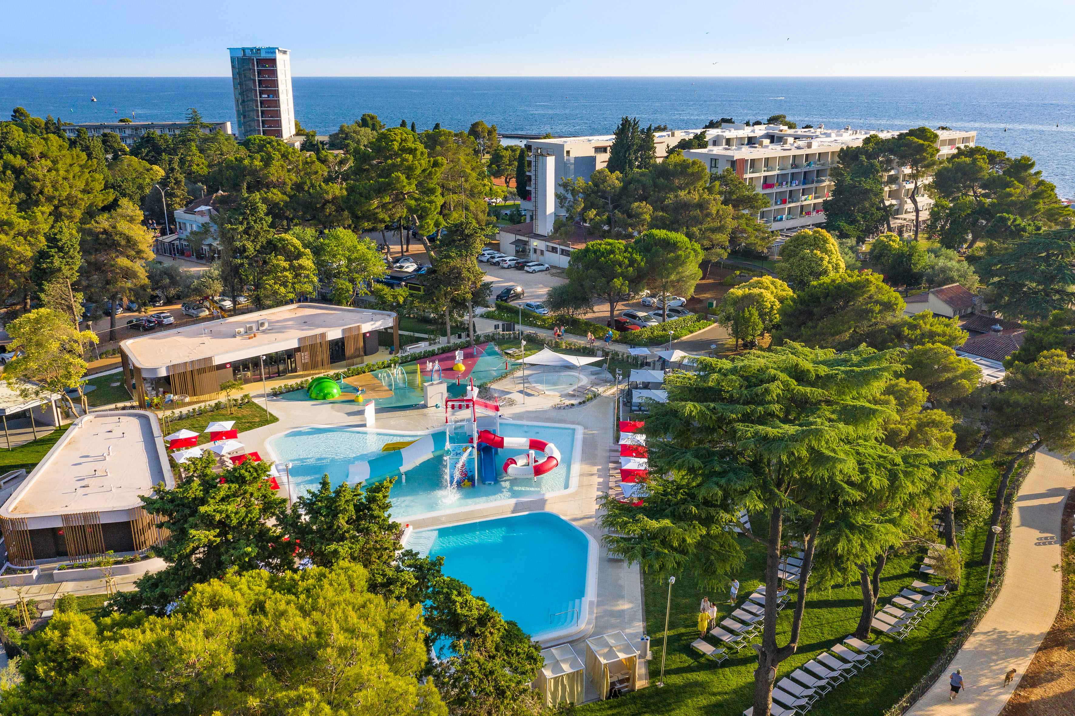 a swimming pool and trees by a building