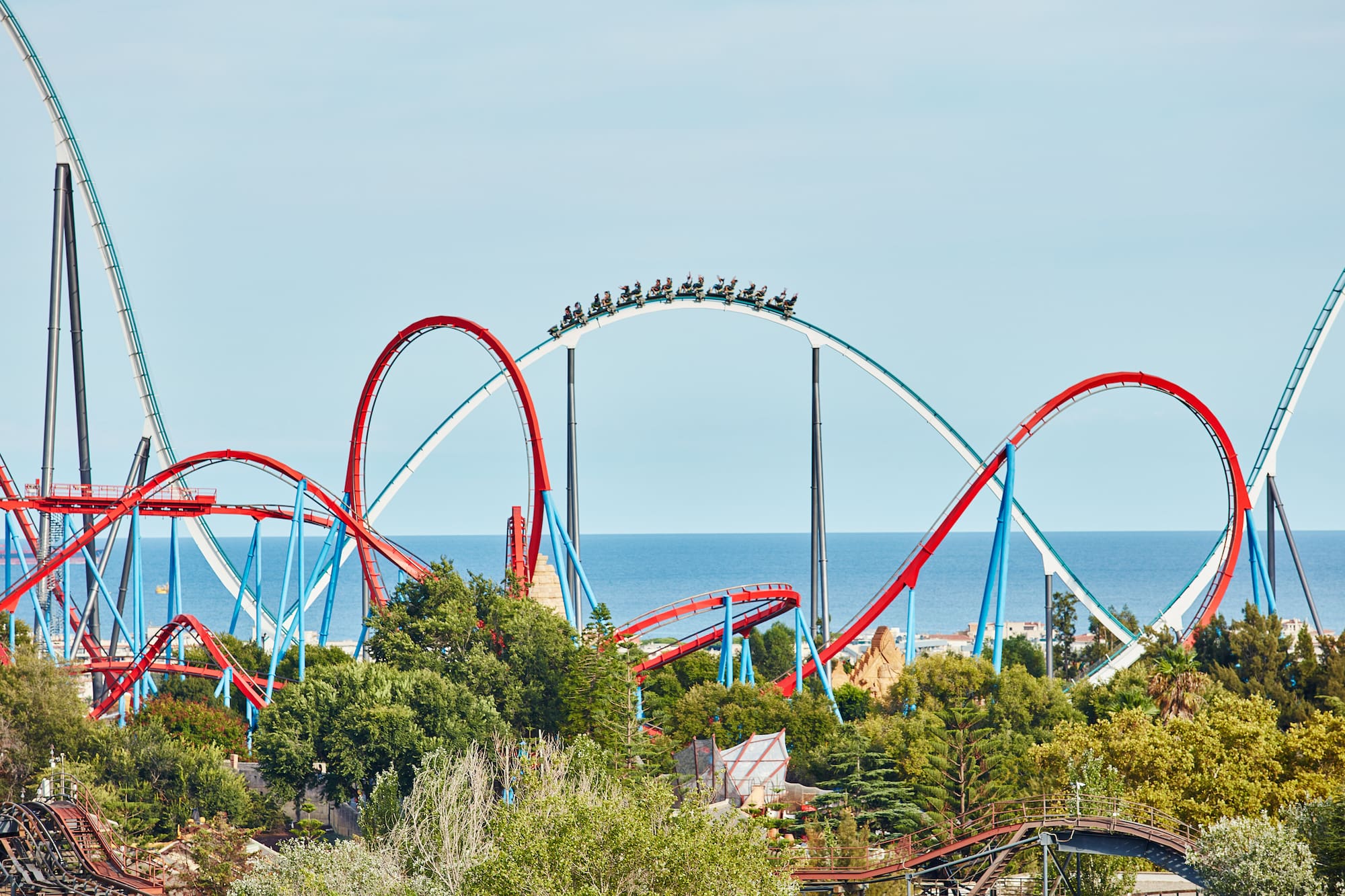 a roller coaster with people on it with PortAventura World in the background