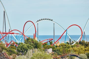 a roller coaster with people on it with PortAventura World in the background