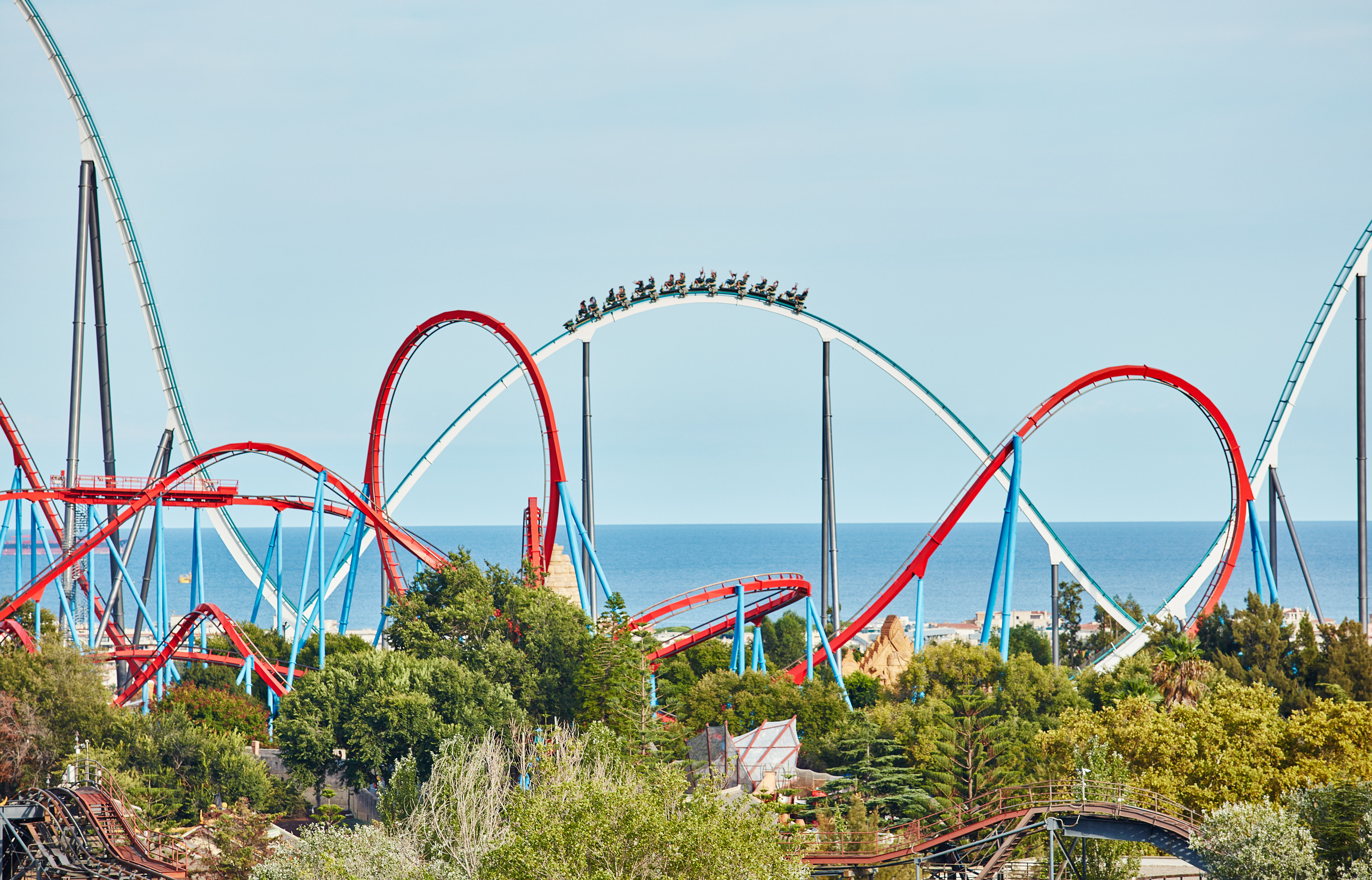 a roller coaster with people on it with PortAventura World in the background
