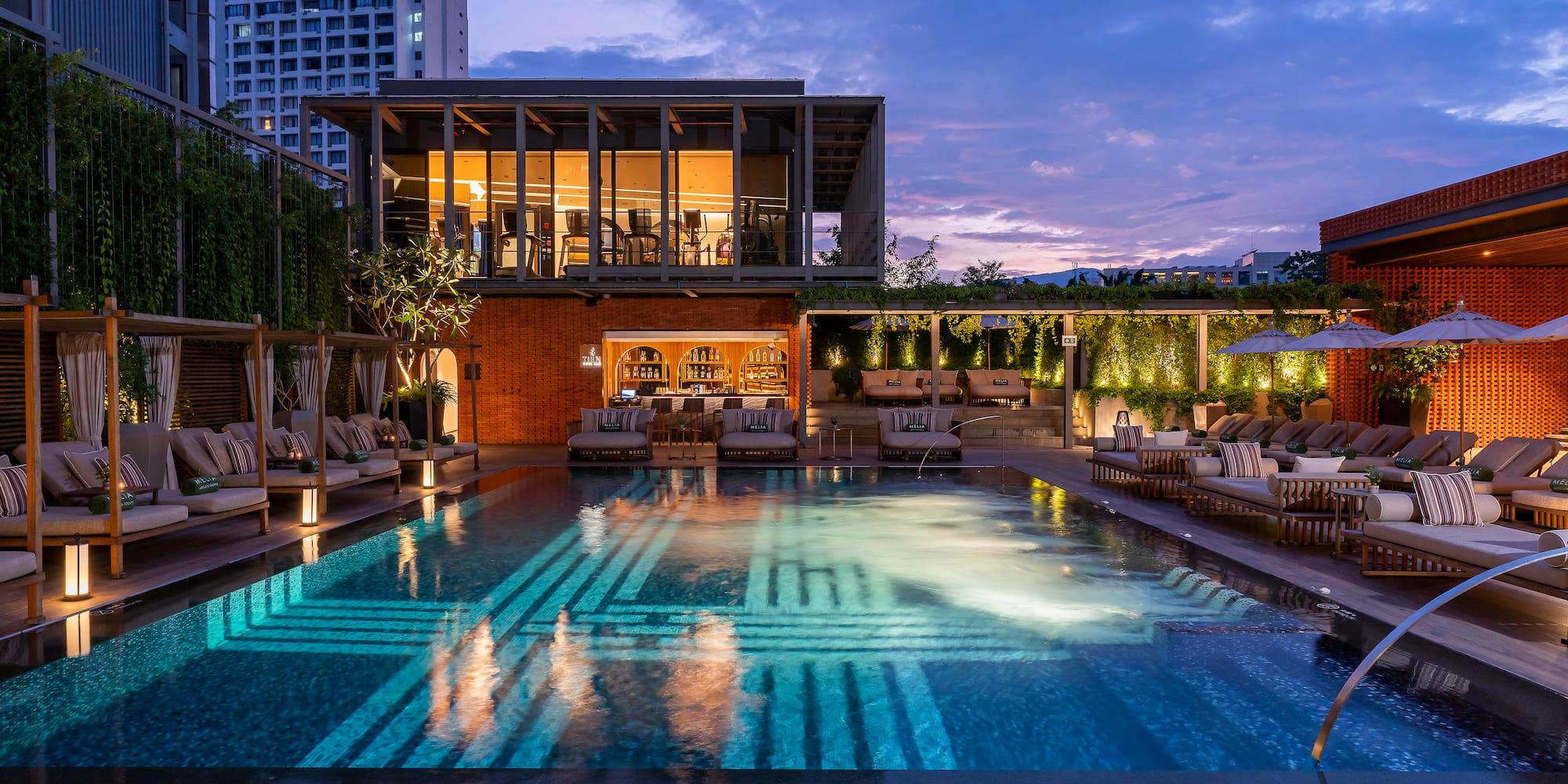 a pool with lounge chairs and a building in the background