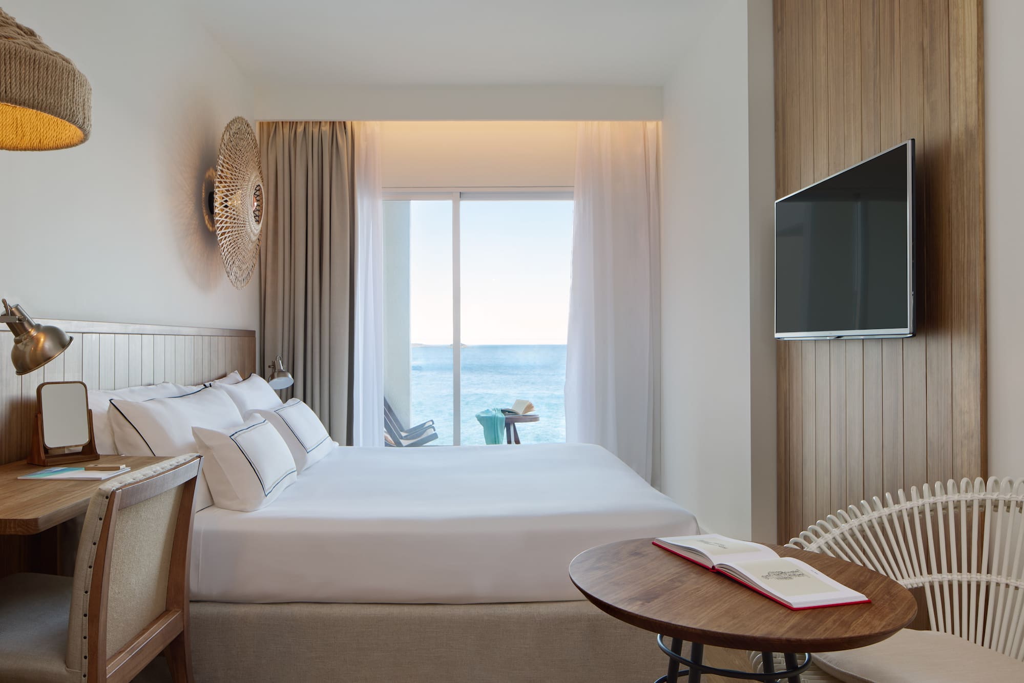 a room with a bed and a table and a television