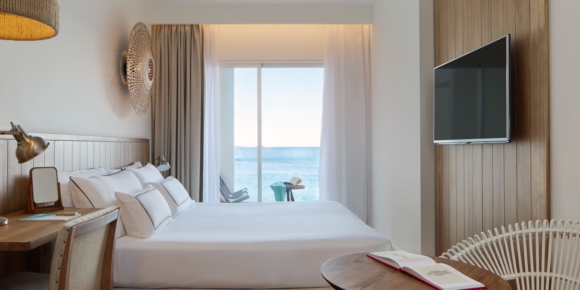 a room with a bed and a table and a television