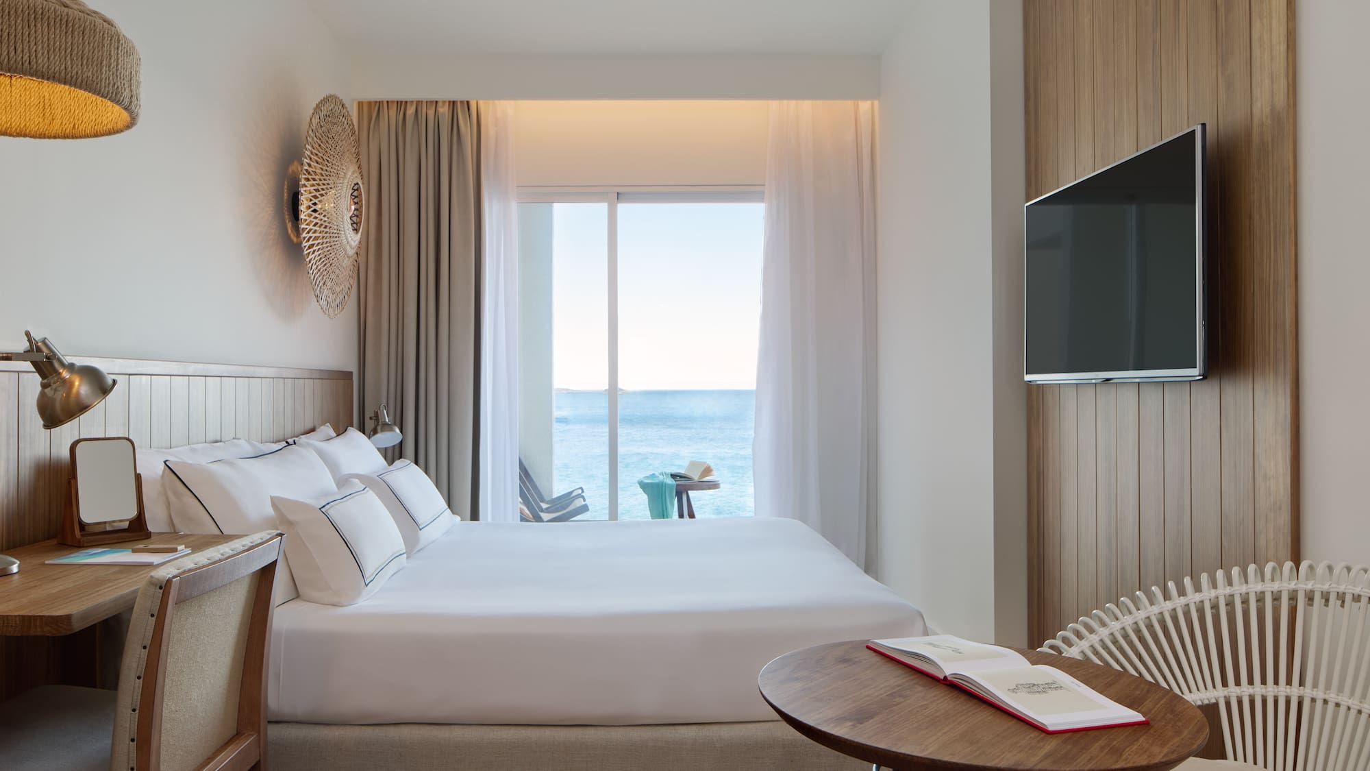 a room with a bed and a table and a television