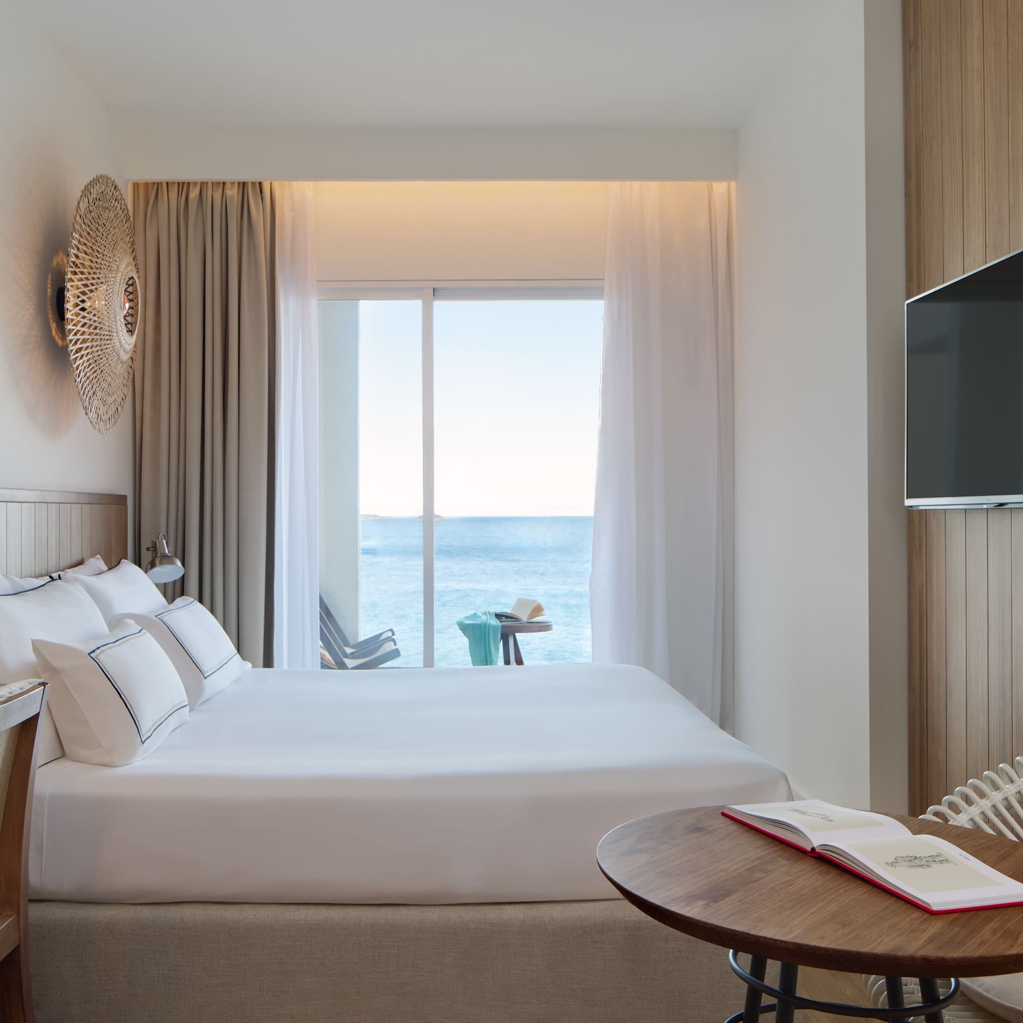 a room with a bed and a table and a television