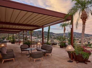 a patio with chairs and tables and plants