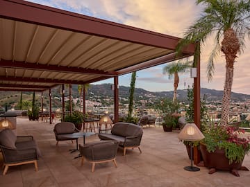 a patio with chairs and tables and plants