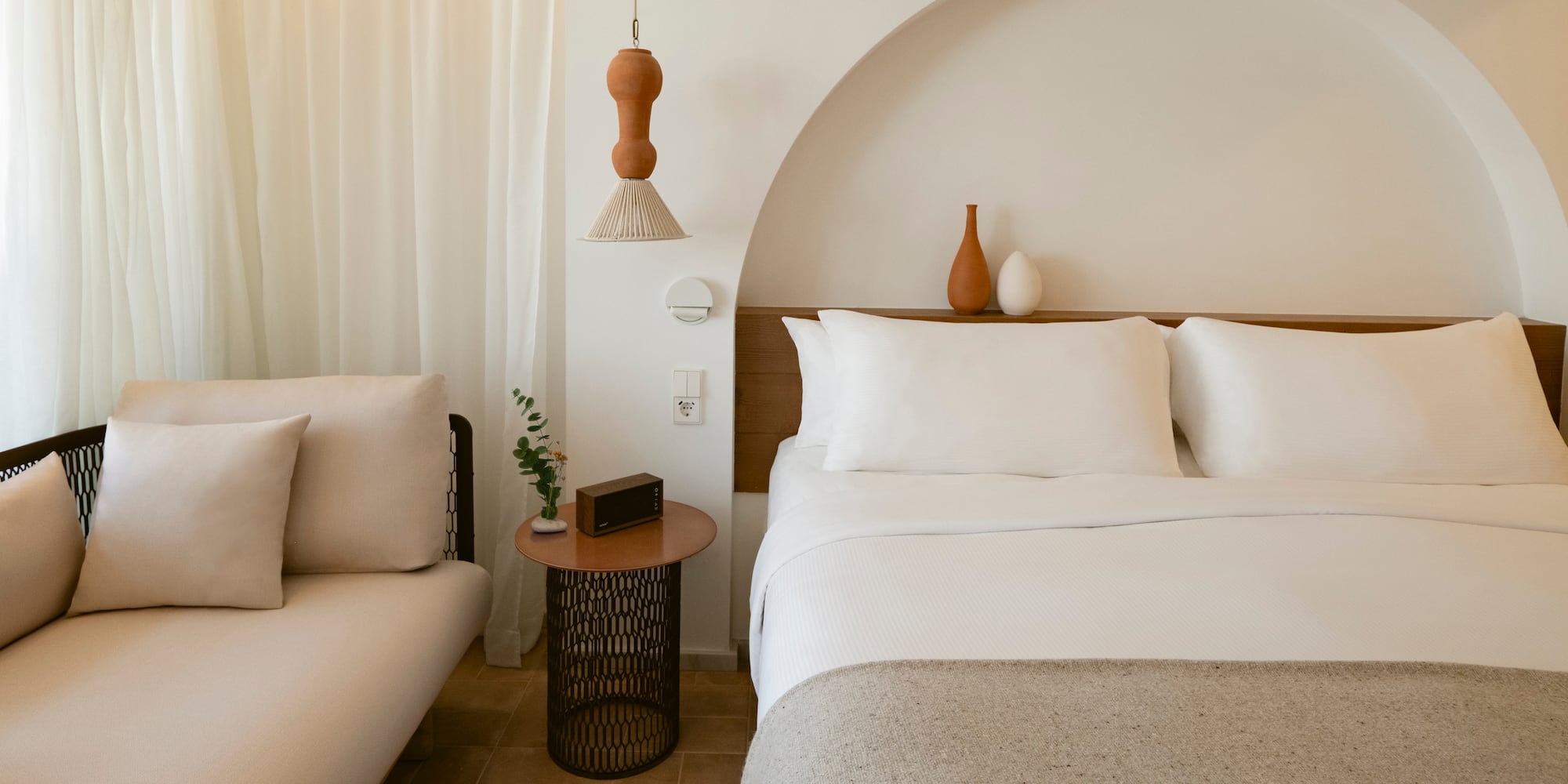 a bed with pillows and a couch in a room