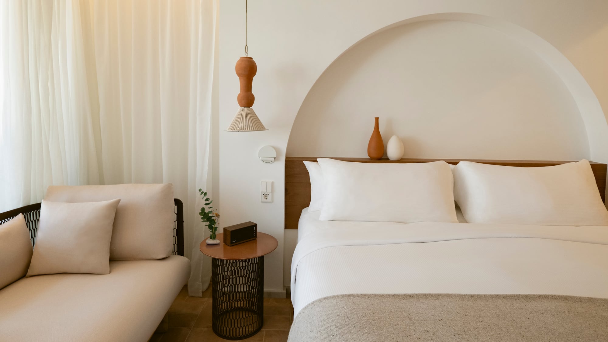 a bed with pillows and a couch in a room