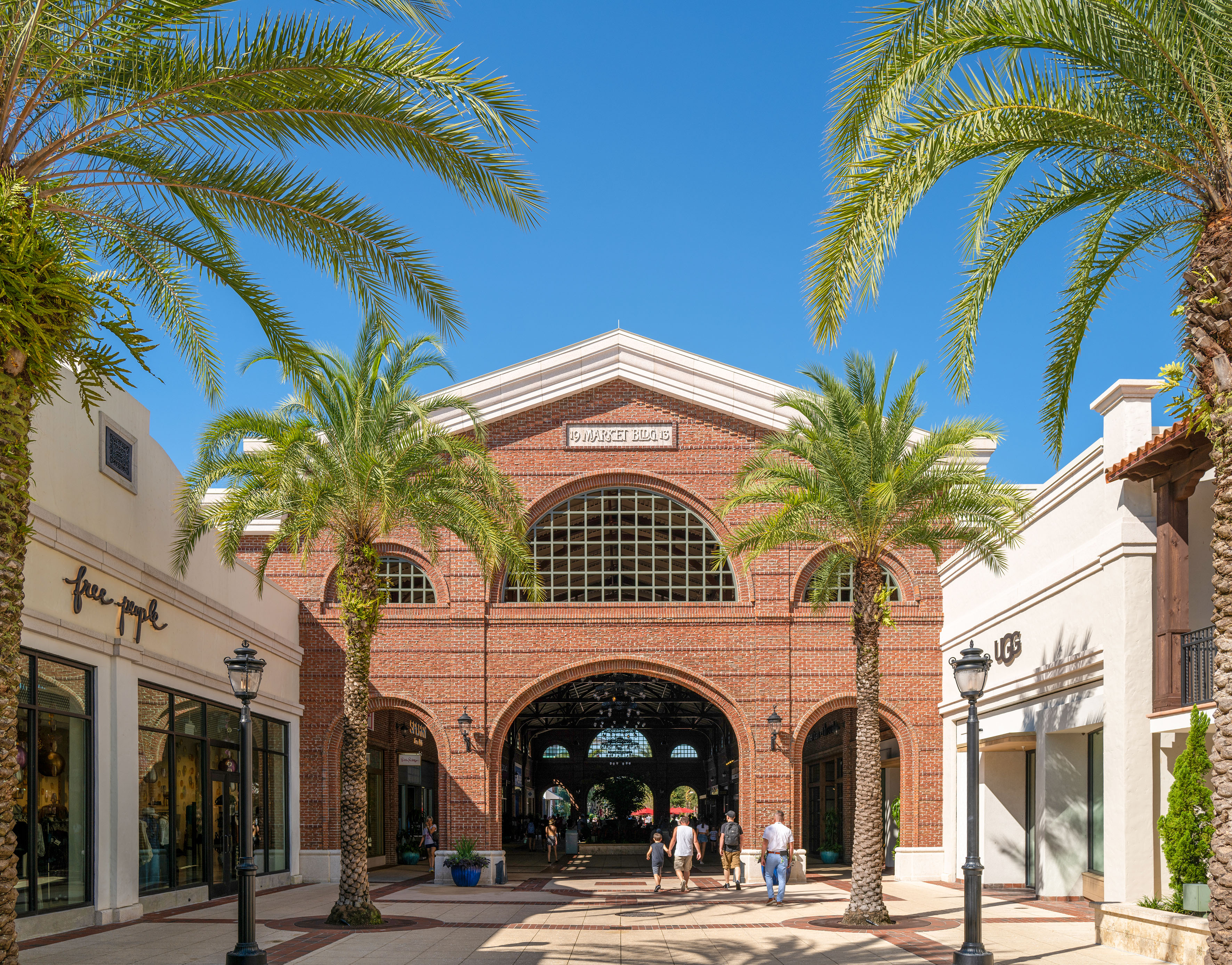 Brick Market Building 19 at Disney Springs, framed by palm trees, shoppers. - Premium Outlet - Meliá Orlando Celebration, Orlando