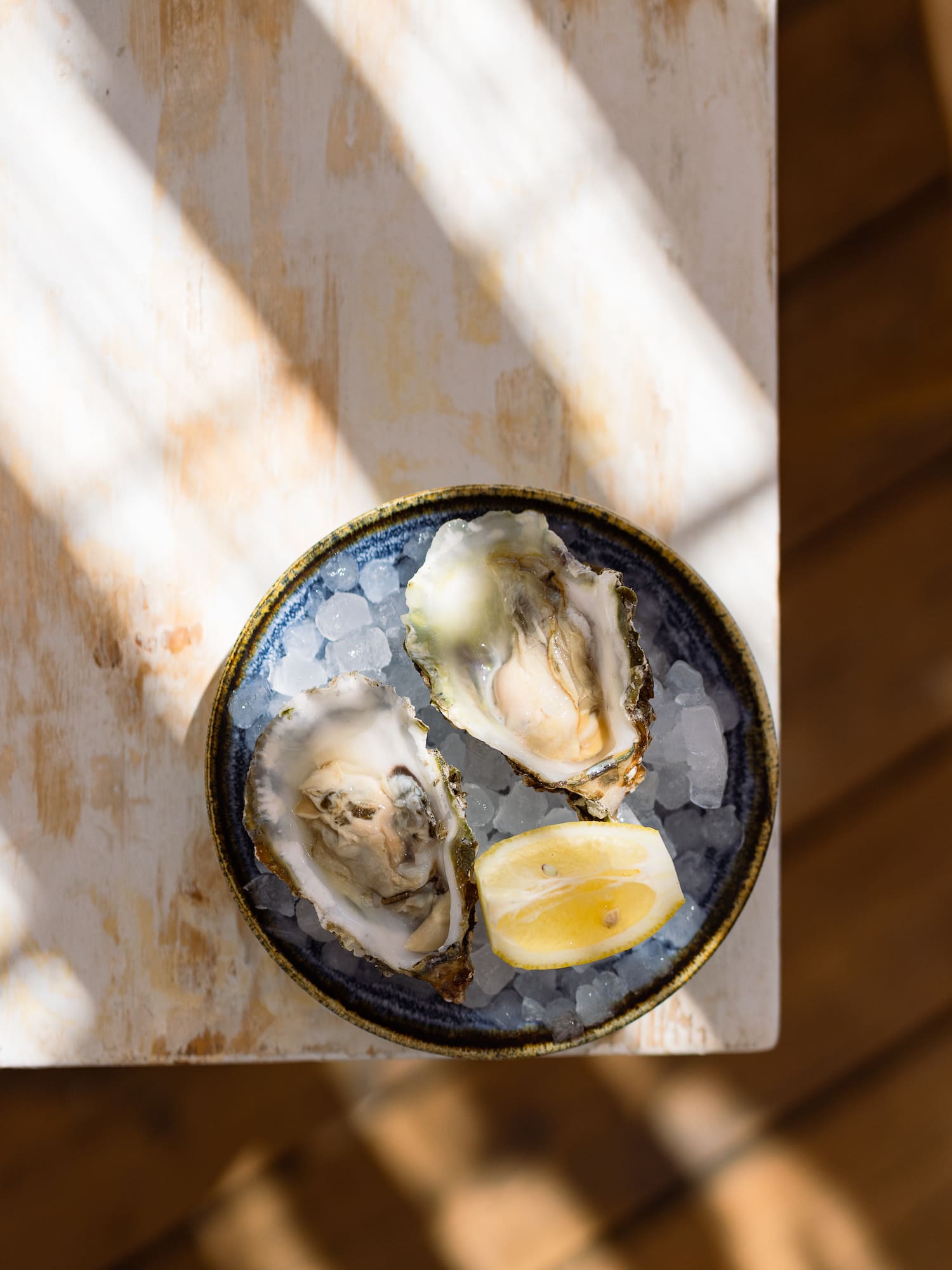 a plate of oysters and lemon on ice