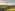 Helicopter flying above green rolling hills, golden sunset. Tuscany landscape.
