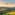 Helicopter flying above green rolling hills, golden sunset. Tuscany landscape.