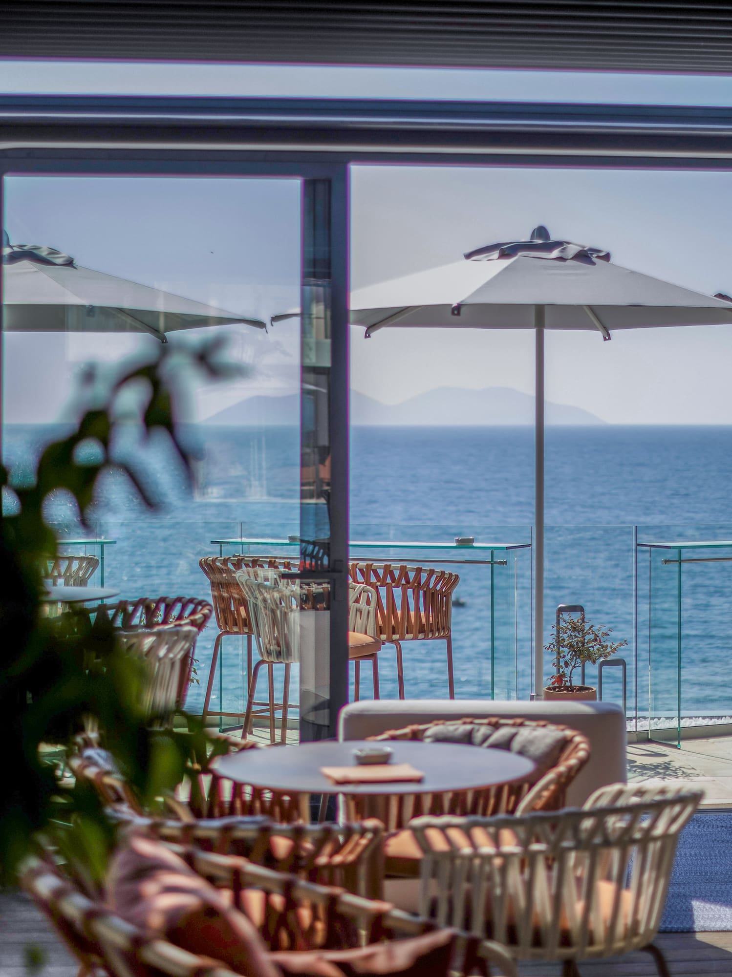 a patio with chairs and umbrellas overlooking the ocean