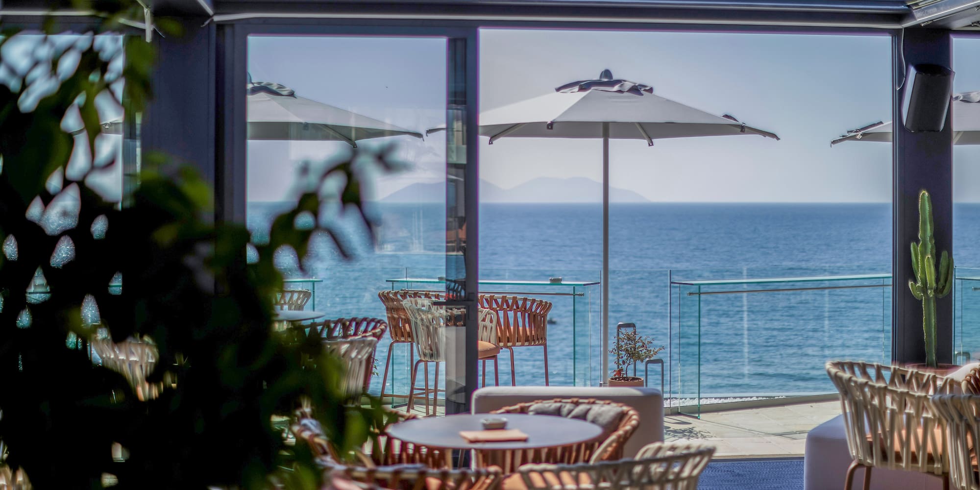 a patio with chairs and umbrellas overlooking the ocean