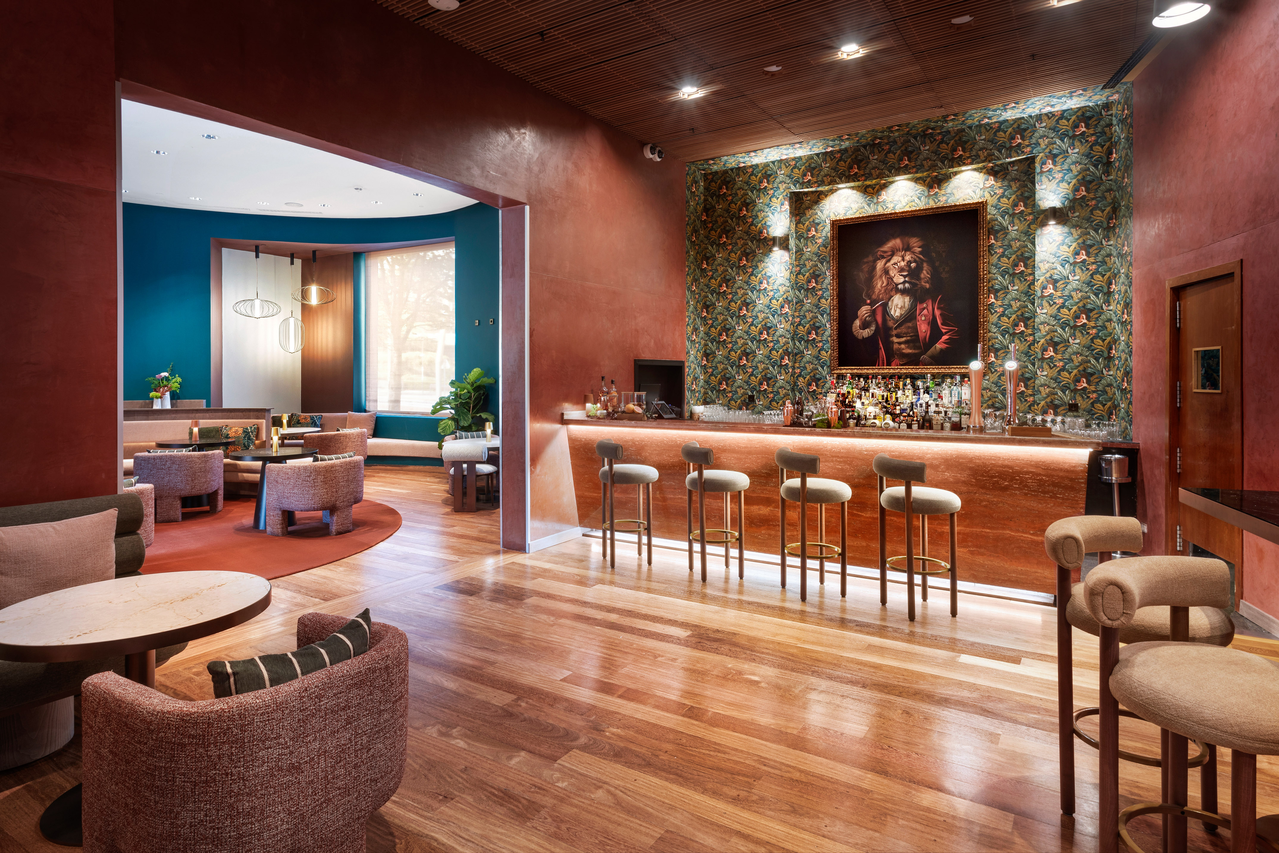 Elegant hotel bar and lounge with lion portrait, bar, and contemporary seating.