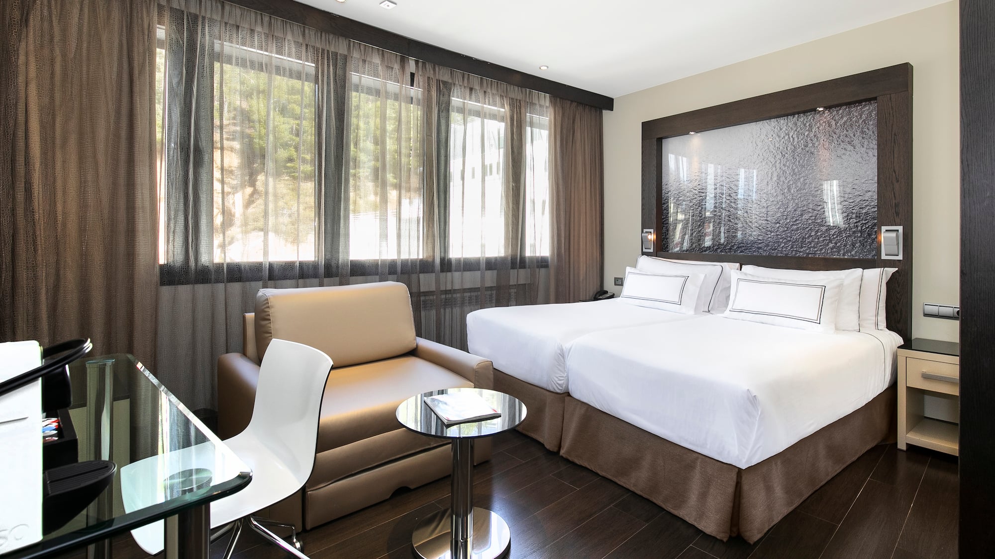 a room with two beds and a chair