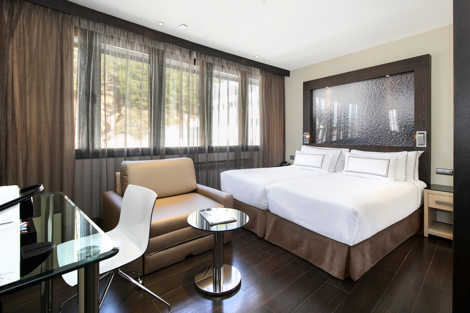 a room with two beds and a chair