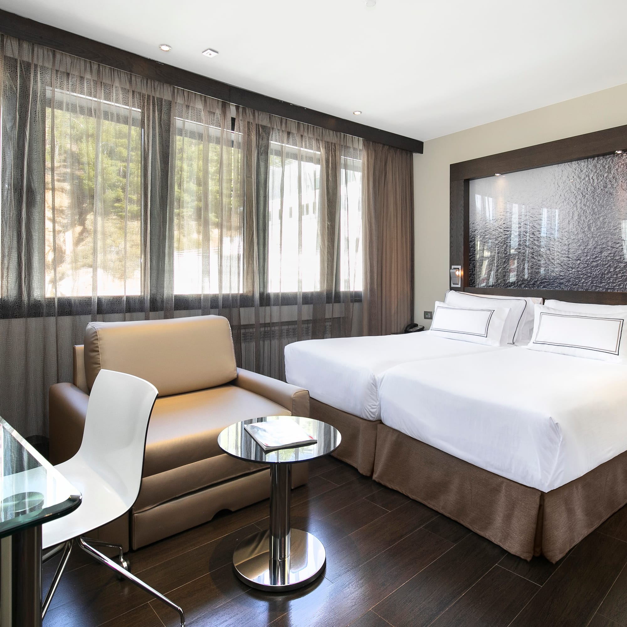 a room with two beds and a chair