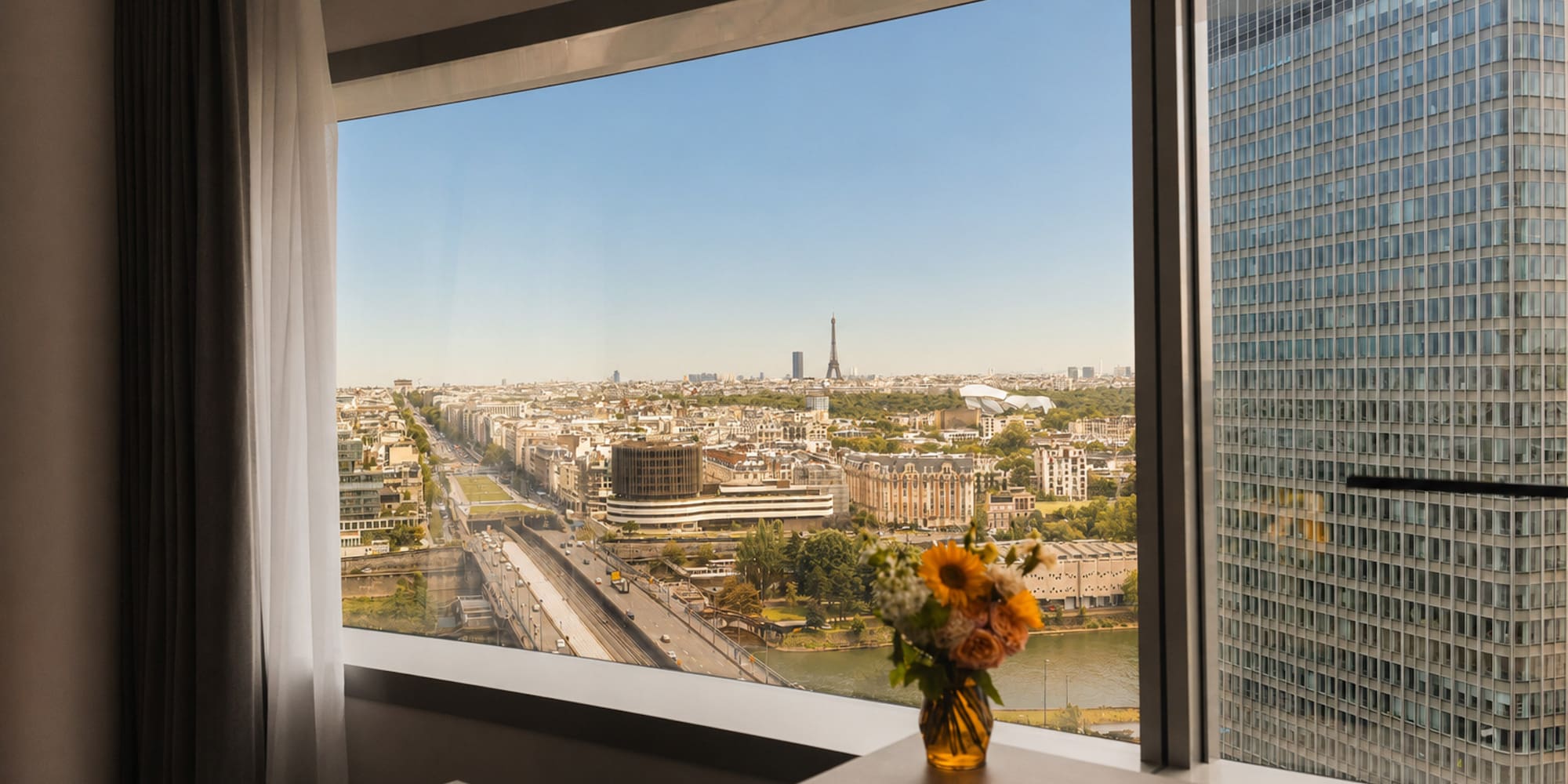 Panoramic Paris hotel view with Eiffel Tower, Seine River, cityscape.
