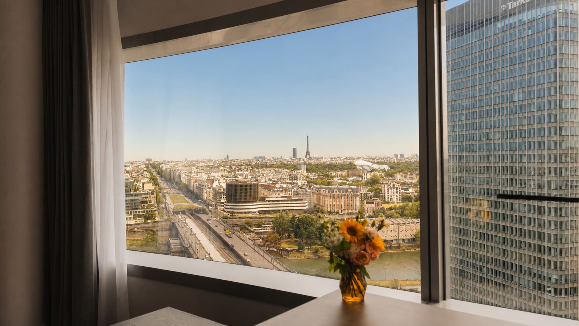 Panoramic Paris hotel view with Eiffel Tower, Seine River, cityscape.