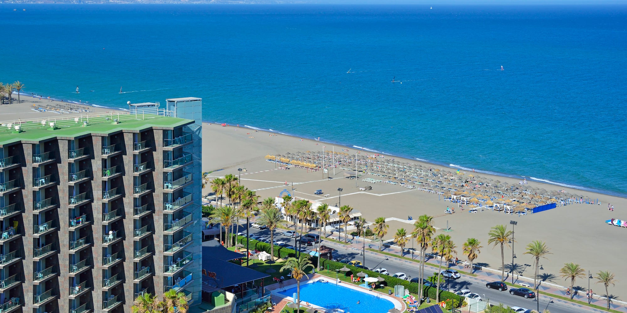 a beach with a swimming pool and buildings