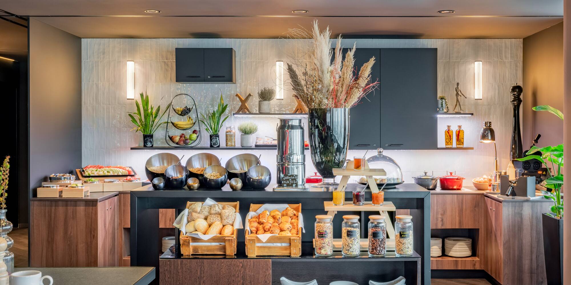 Modern breakfast buffet with fresh pastries, cereals, fruit, and juices.