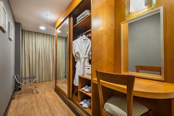 a room with a mirror and a robe on a swinger