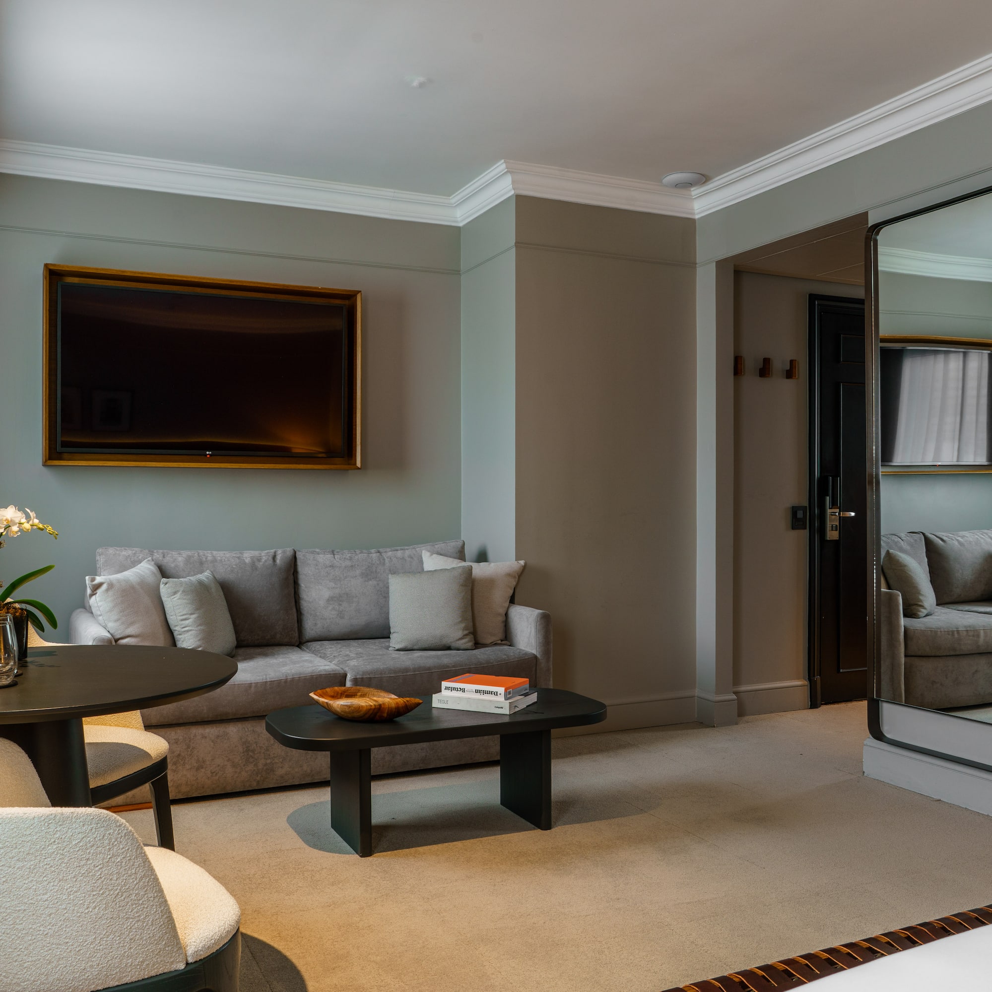 a living room with a mirror and couches