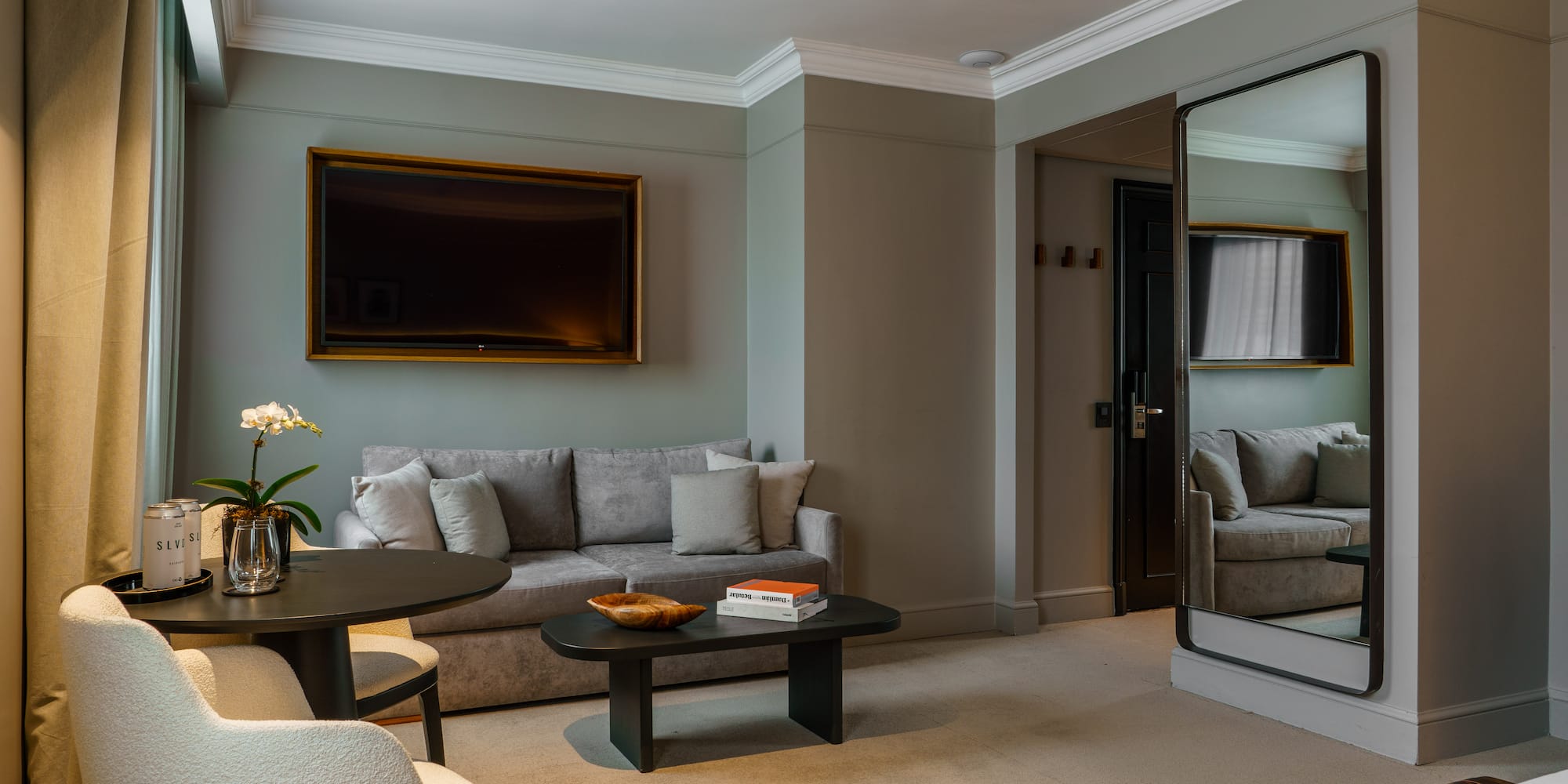 a living room with a mirror and couches