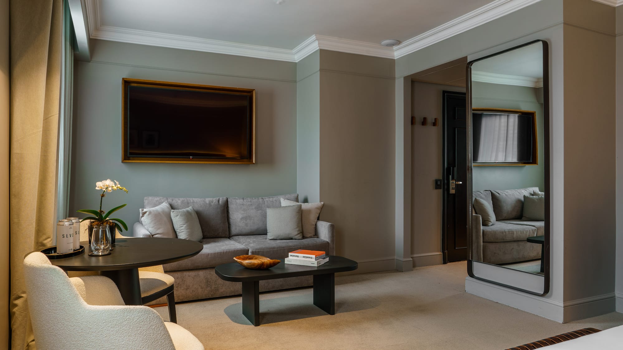 a living room with a mirror and couches