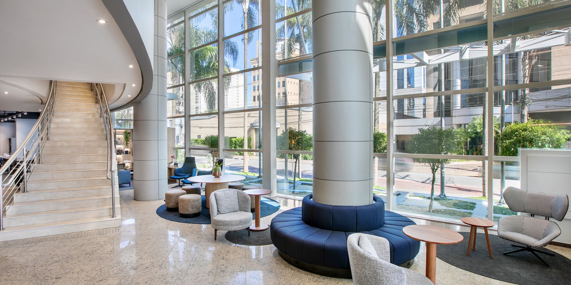 a large glass window with a large column and chairs