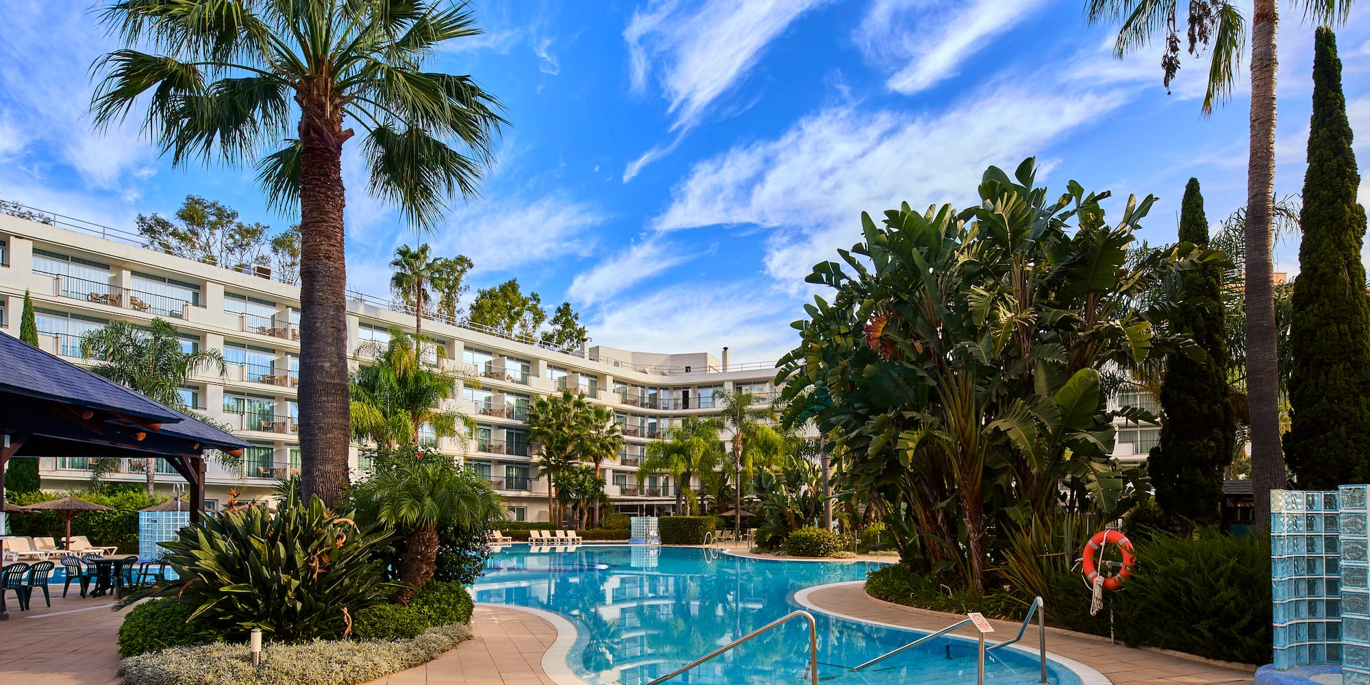a pool with palm trees and a building