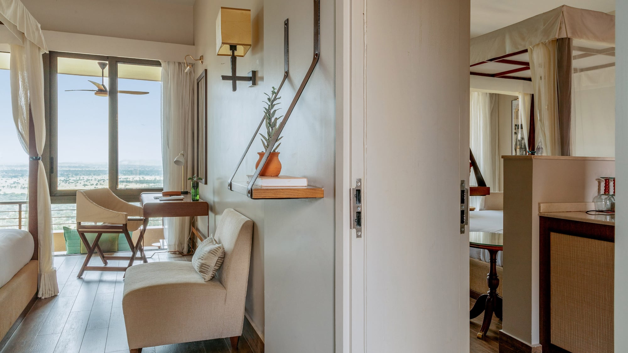 Hotel room with expansive window, landscape view, and comfortable seating.