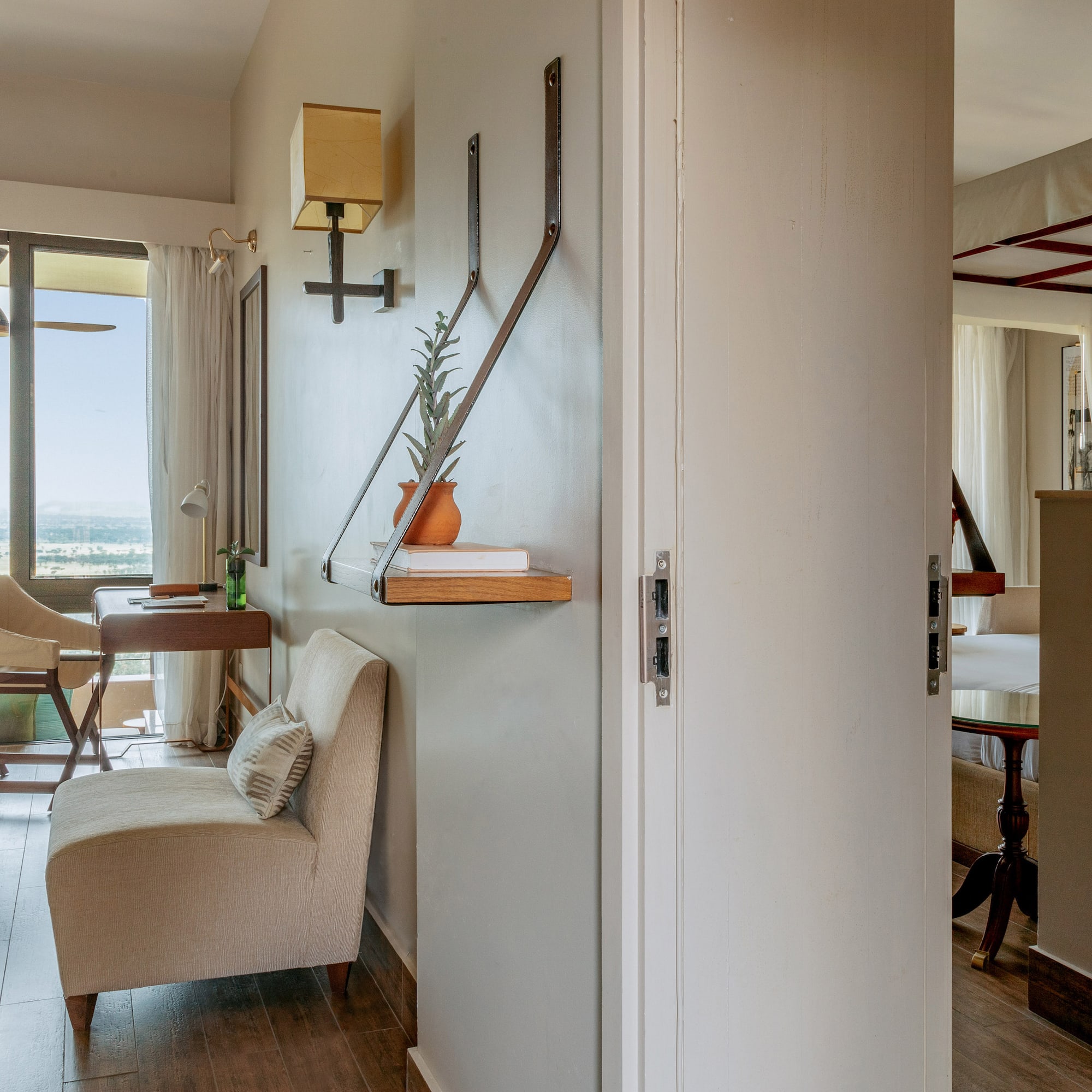 Hotel room with expansive window, landscape view, and comfortable seating.