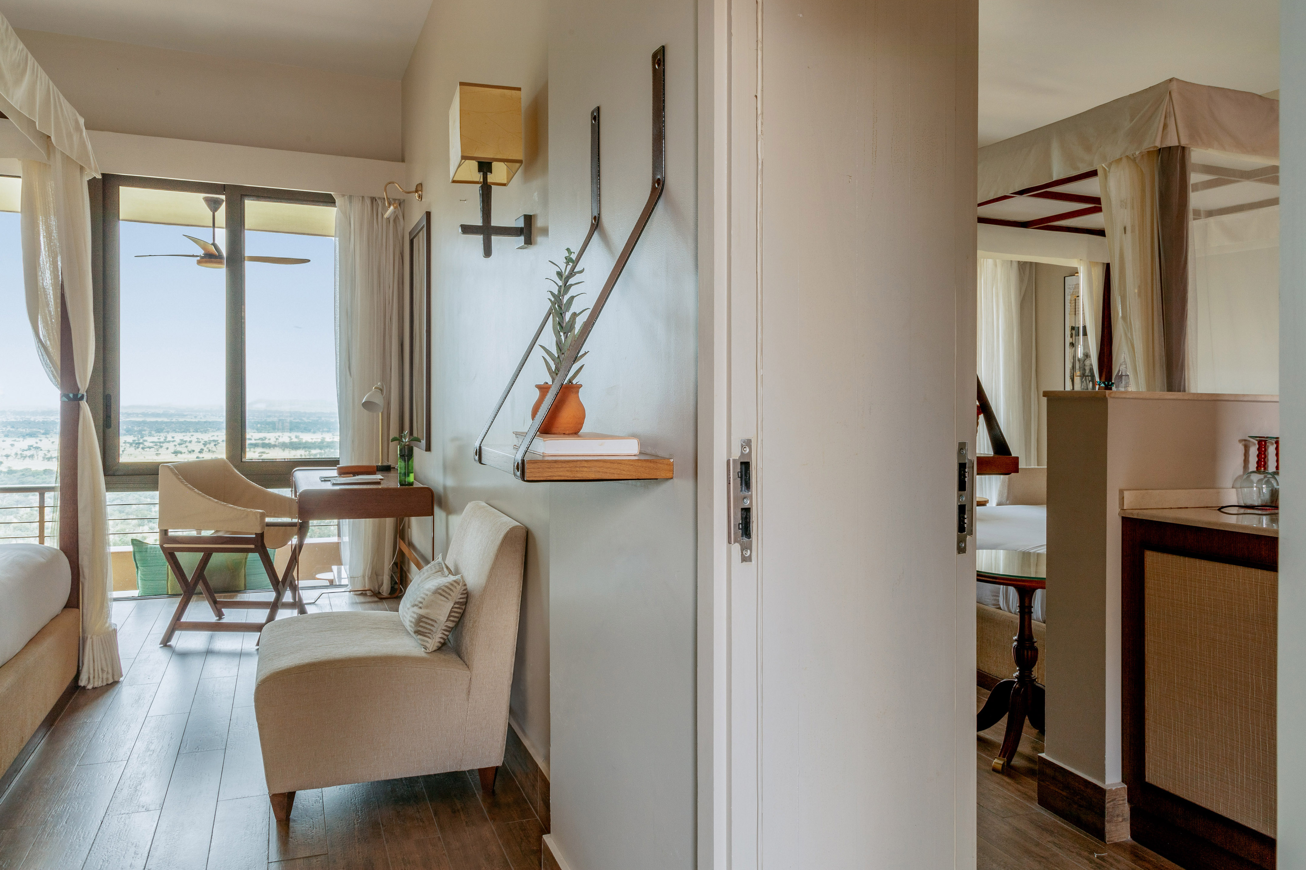 Hotel room with expansive window, landscape view, and comfortable seating.