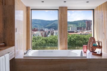a bathtub in a bathroom with a view of a city