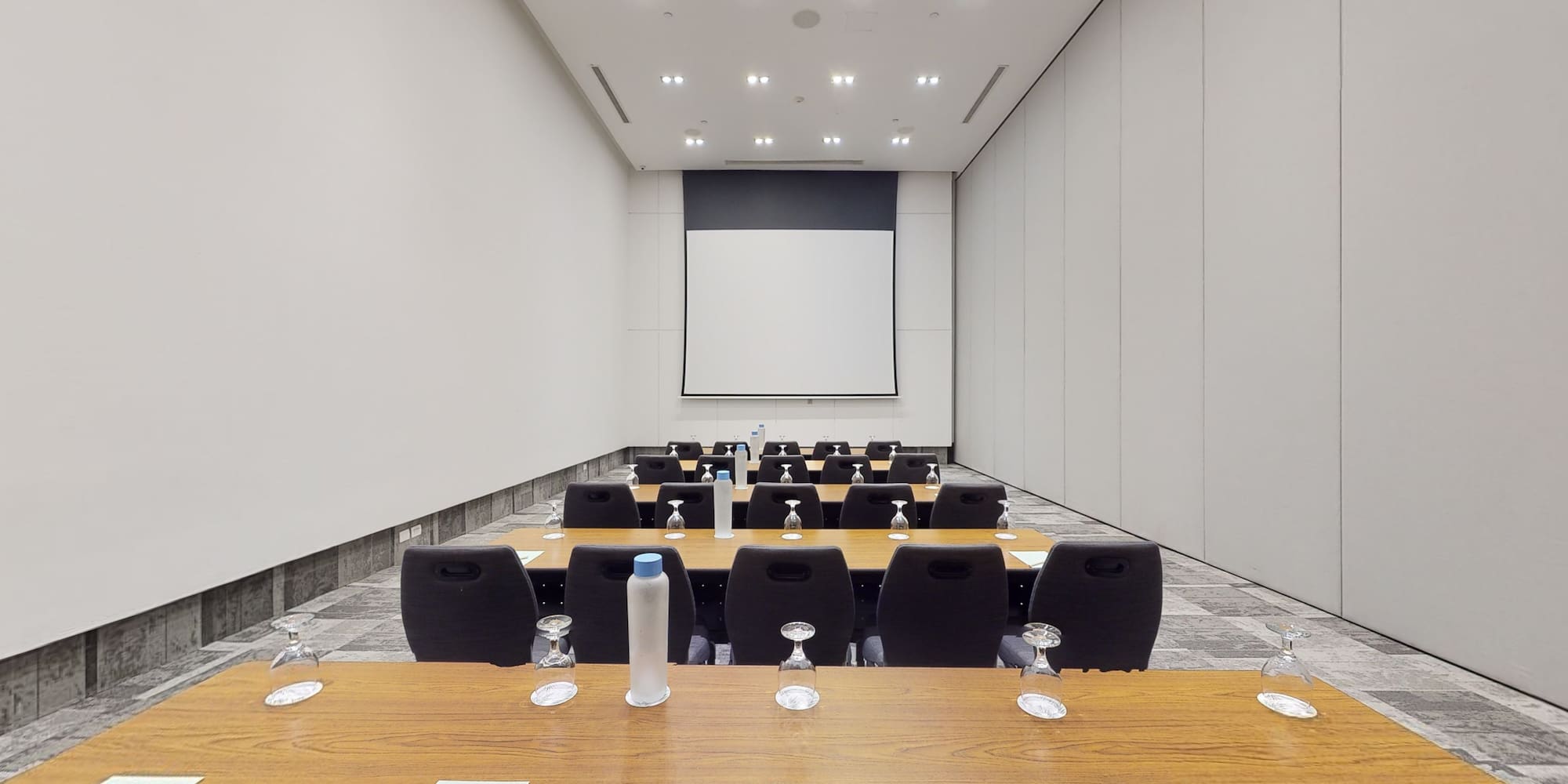 a room with a projection screen and tables