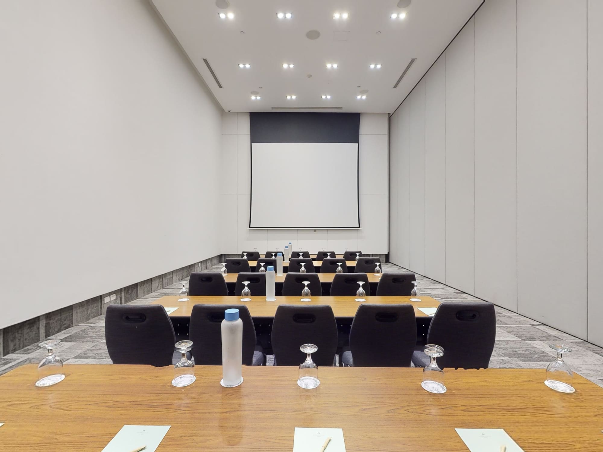 a room with a projection screen and tables